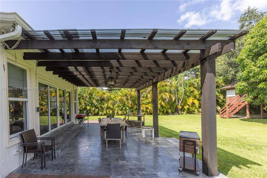 covered patio with ceiling fans and travertine floor.