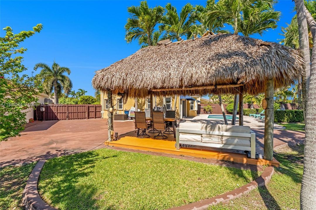 Tropical tiki hut area for shade and relaxation—perfect for BBQs, entertaining, or outdoor dining.