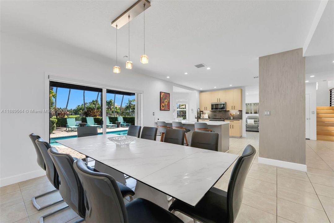 Elegant dining space with stylish lighting and window views of the backyard oasis.