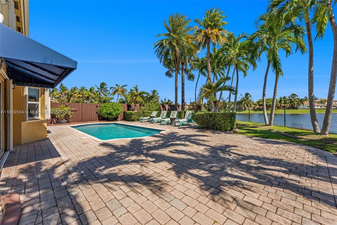 Resort-style backyard with a sparkling pool surrounded by palm trees—ideal for family fun and Florida outdoor living.