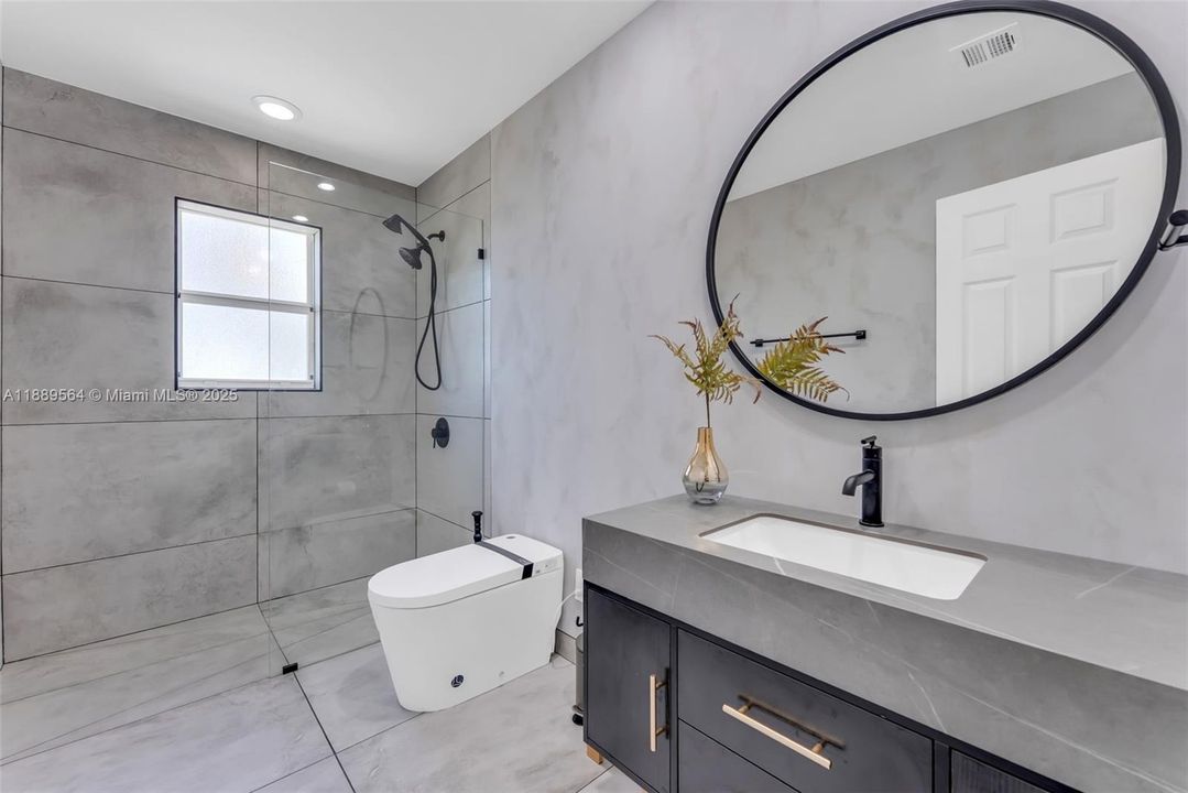 Modern bathroom with designer tile, glass-enclosed shower, and updated fixtures.