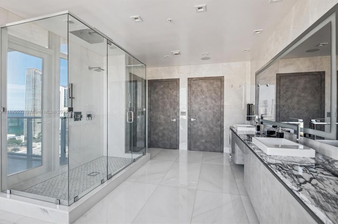 Marble Countertops w/ Dual Sinks & Grohe Fixtures, Seura Lighted Vanishing TV Mirror. Separate Water Closet Room.