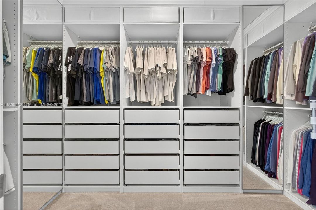 Custom walk-in closet with full built-in organization, including tons of drawer space, double hanging sections, and open shelving to keep everything neat and easy to see.