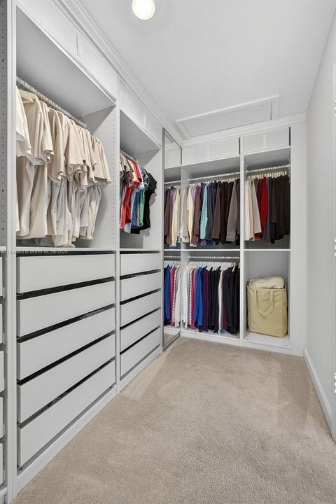 The closet offers room for both his and hers wardrobes with mirrored panels and smart storage throughout — no need for extra dressers.