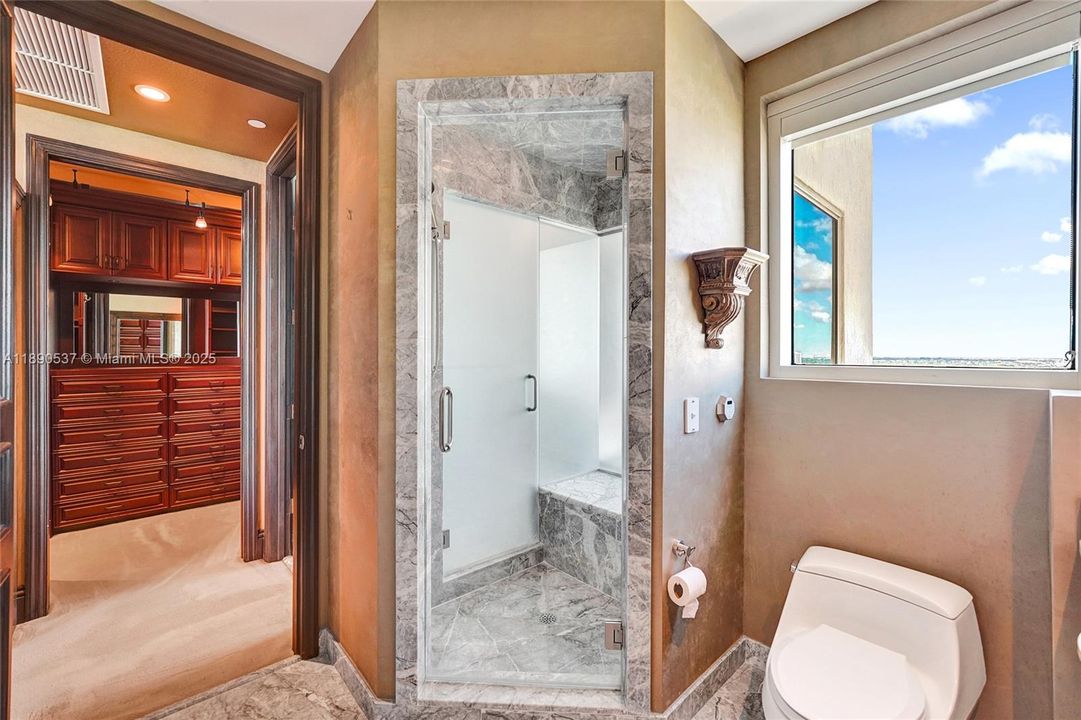 Bathroom with steam shower directly across from the bedroom.....window with the natural light!  Peek through the window at the city and water views too!