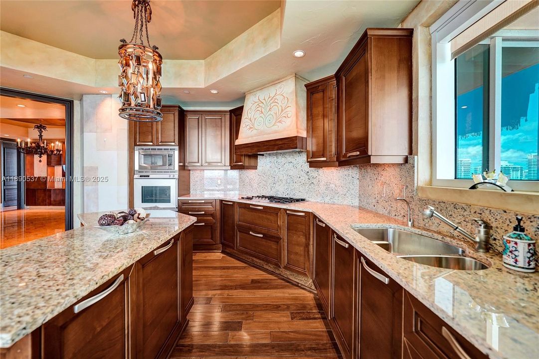 Granite counters, double sink and lots of storage .....gorgeous wood floors too which complement the beautiful marble floors!