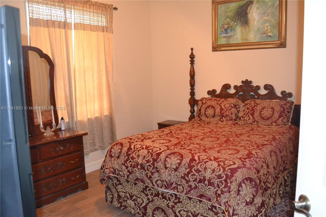 Guest bedroom 3 featuring wood tile flooring and baseboards