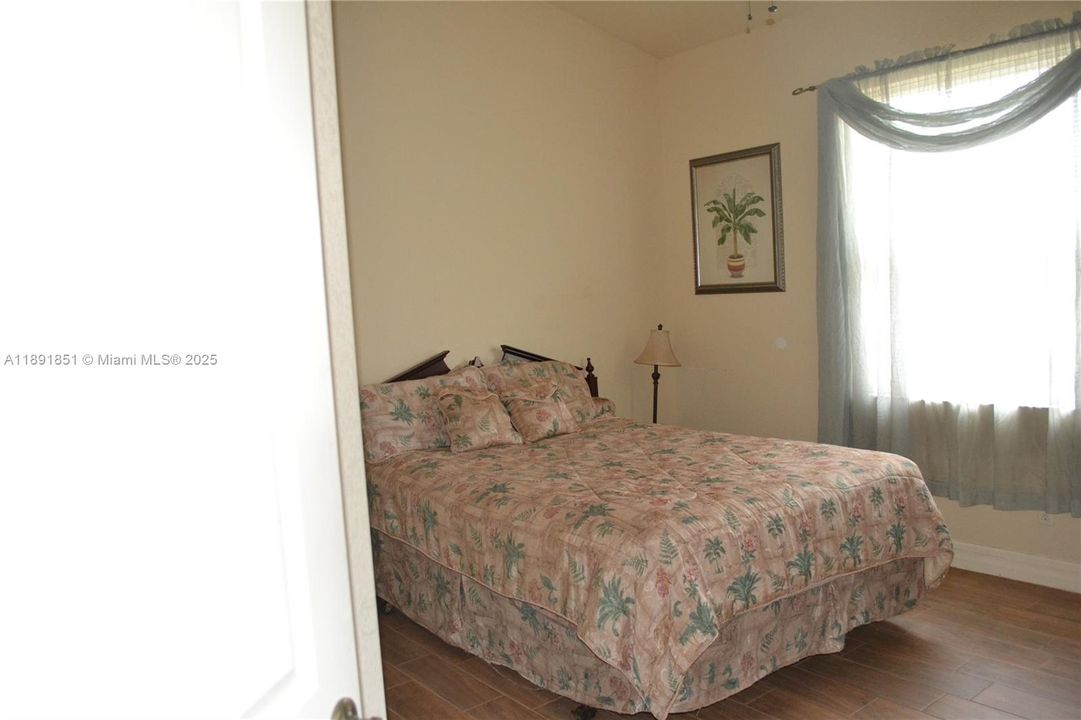 Guest bedroom 2 featuring wood tiled floors and baseboards