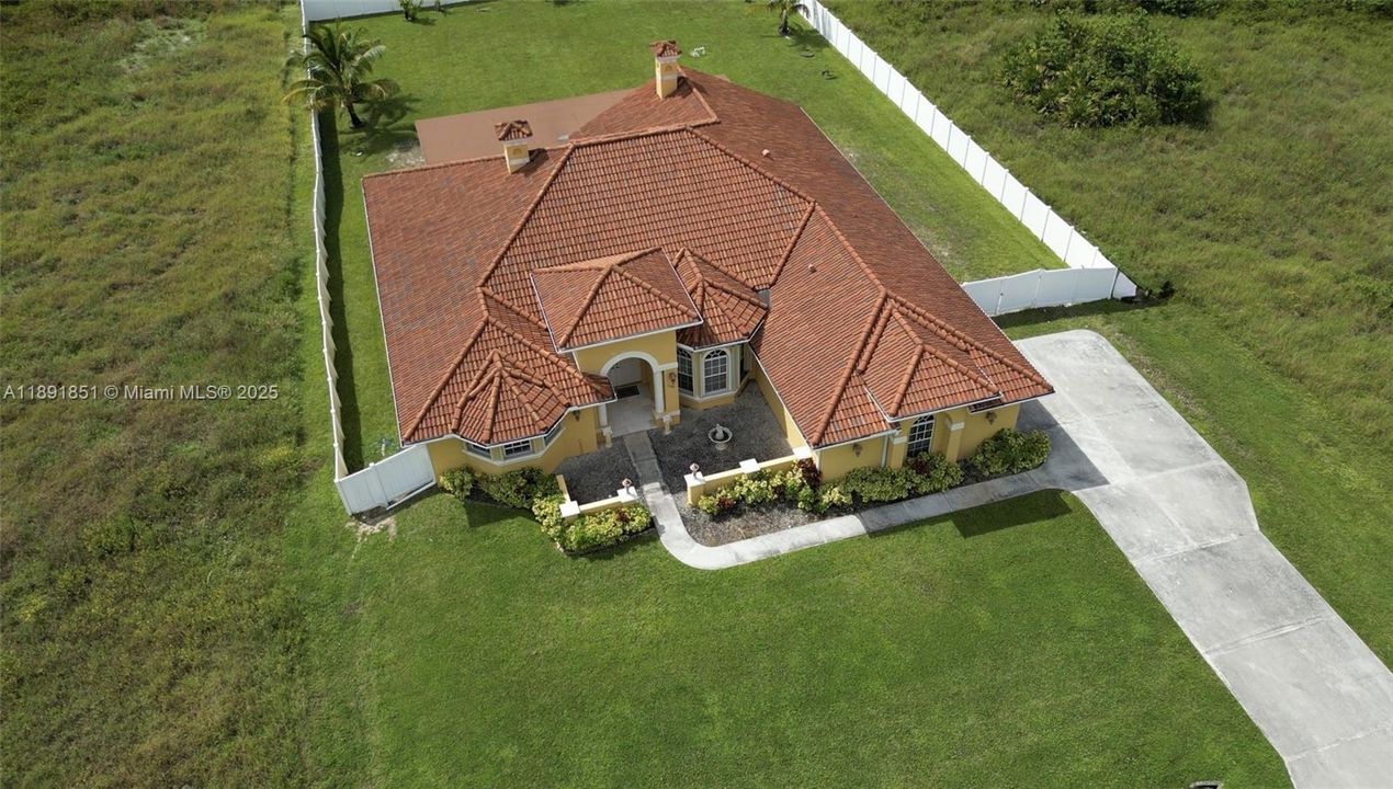 View of property from above with fully fenced yard, huge backyard and extended driveway