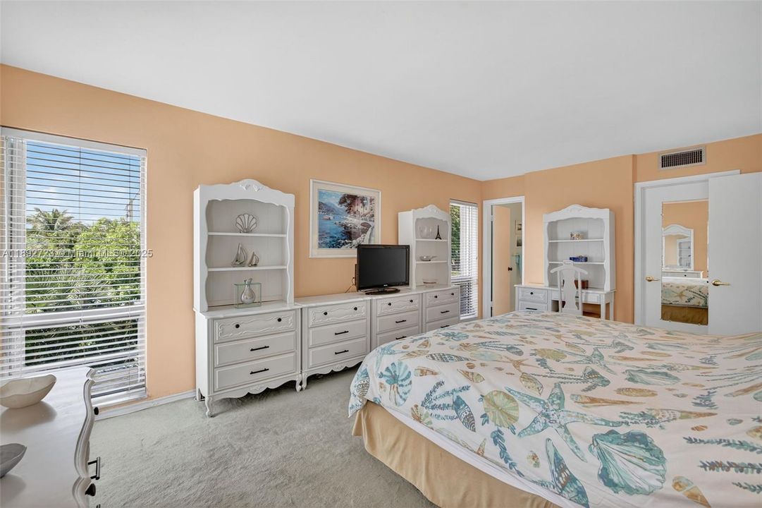 Oversized primary bedroom w/ room for all your furniture and windows on both sides - great natural light and space w/ a walk in closet and en suite bathroom