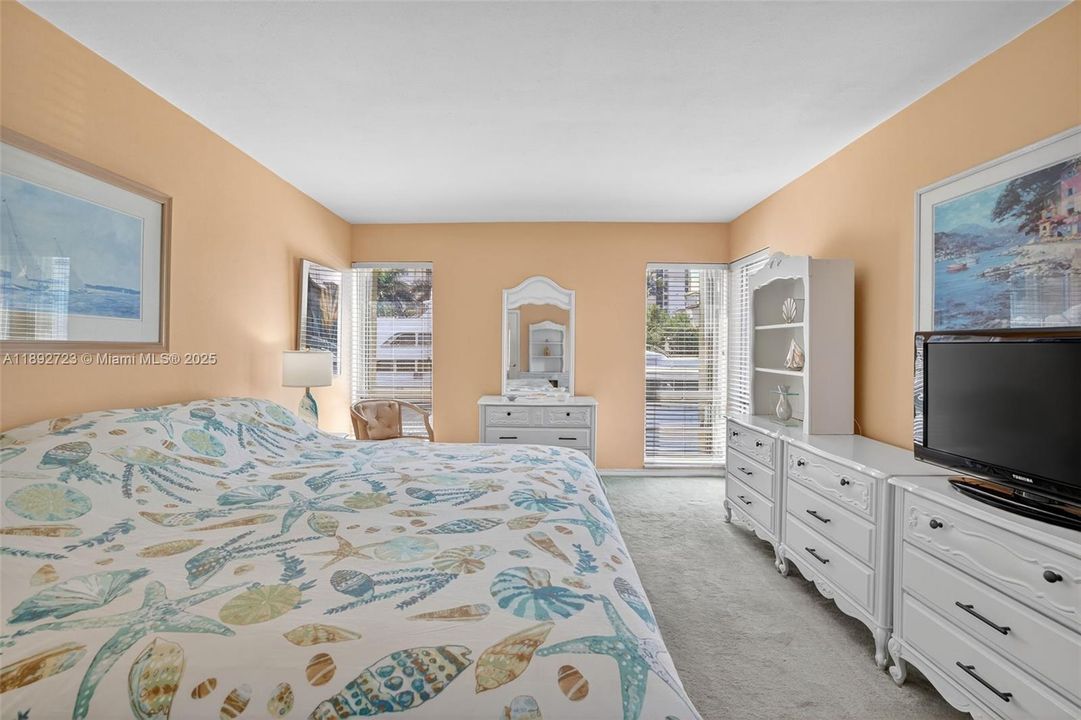 Oversized primary bedroom w/ room for all your furniture and windows on both sides - great natural light and space w/ a walk in closet and en suite bathroom