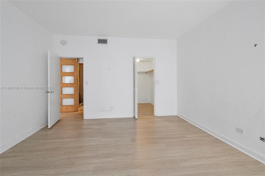 Interior of the primary bedroom shows access and walk-in closet.