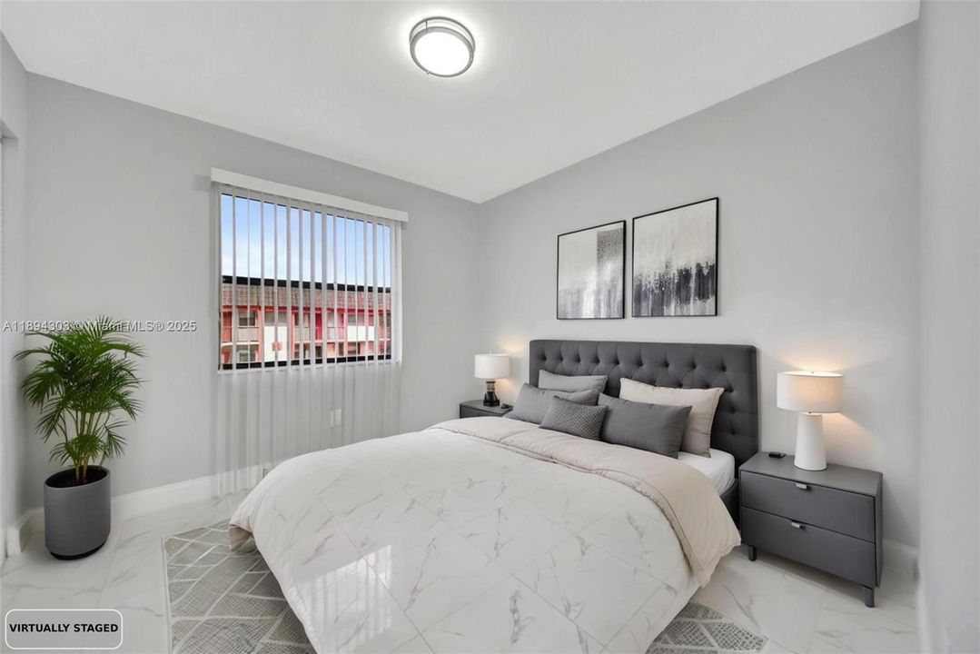 The bedroom continues that same updated feel with the new floors, new trim, and fresh paint. Soft gray walls, upgraded ceiling light, and neutral finishes make it calm and easy to personalize.