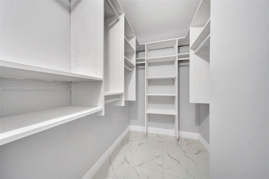 This walk-in closet is a huge bonus — built-in shelving, hanging space, and organizers already in place so you don’t have to add a thing. The same new tile flooring carries in here, and the fresh paint and clean white finishes keep the space bright, organized, and ready to actually function like a true primary closet.