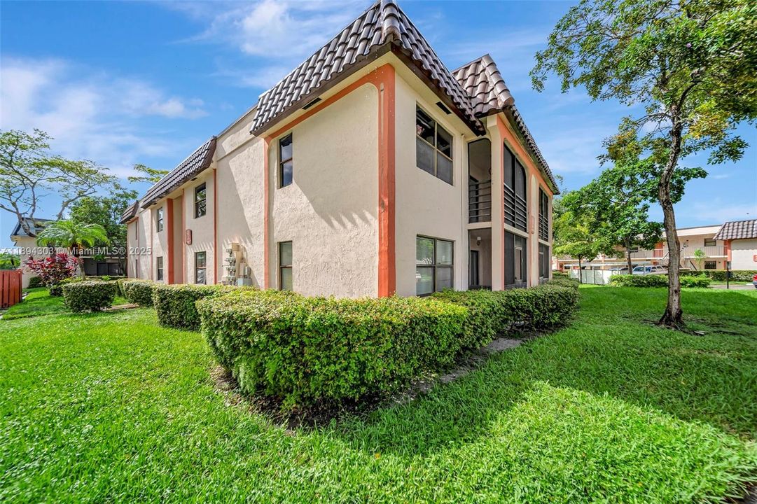 Corner unit surrounded by lush green space — tons of privacy, tropical landscaping, and no upstairs neighbors over most of the living area.