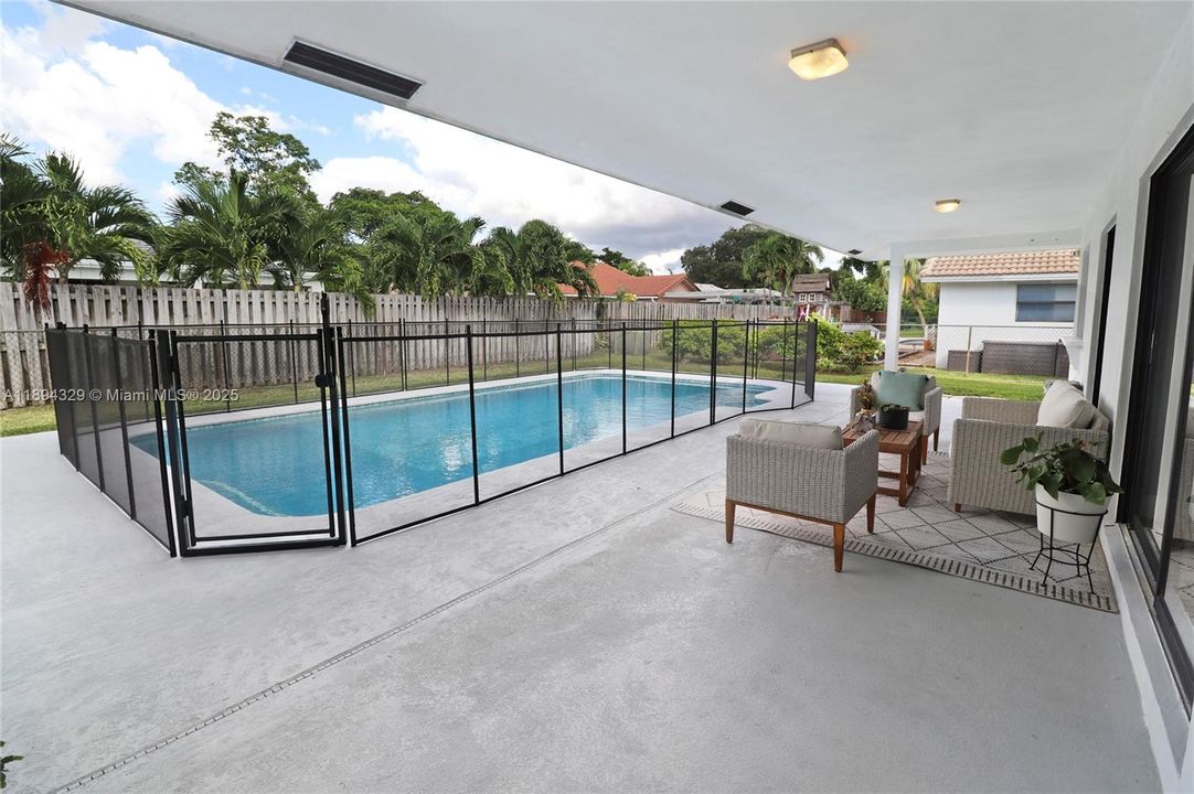 This shaded area enhances the outdoor living experience by offering protection from the sun’s harsh rays, creating a cooler and more comfortable environment for lounging, dining, or socializing. The thoughtful design ensures the space can be enjoyed throughout the day, making it a true extension of the home’s living area.