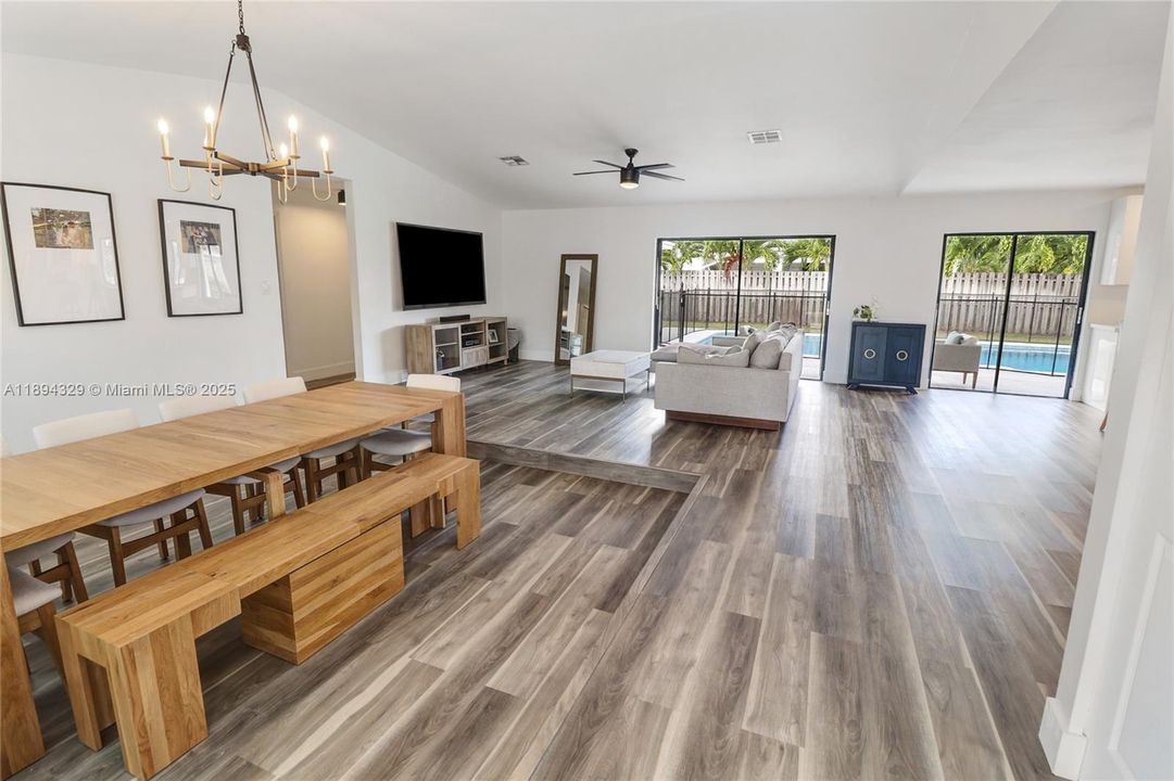From the moment you step through the front door, you're greeted by an open-concept design that flows seamlessly throughout the home. Take note of the striking sunken dining area—a distinctive architectural feature that adds depth and character to the space.