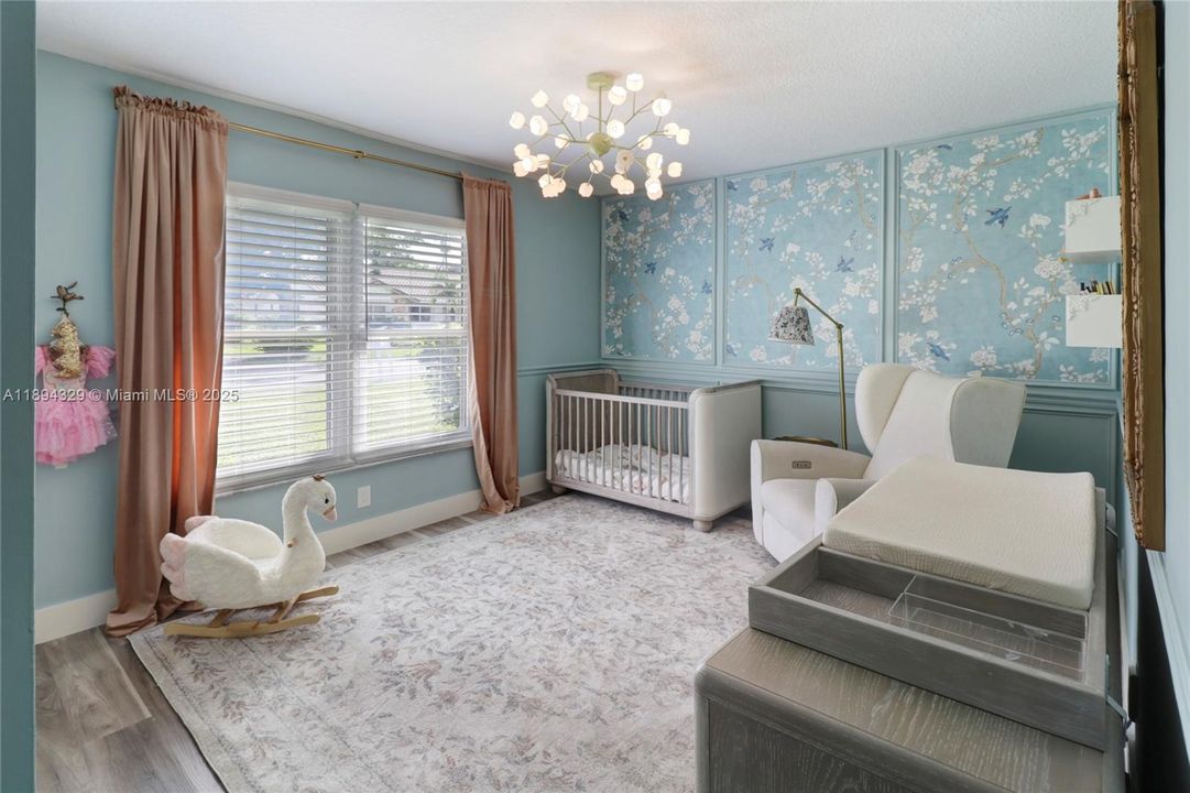 The fourth bedroom remains lovingly decorated for the family's first born, showcasing a serene palette of soft blues and gentle grays.