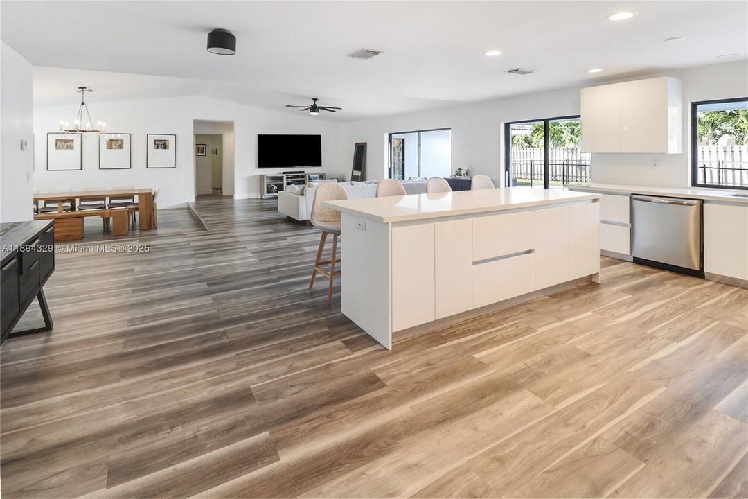 The light wood laminate flooring and crisp white cabinetry contribute to the bright, welcoming atmosphere