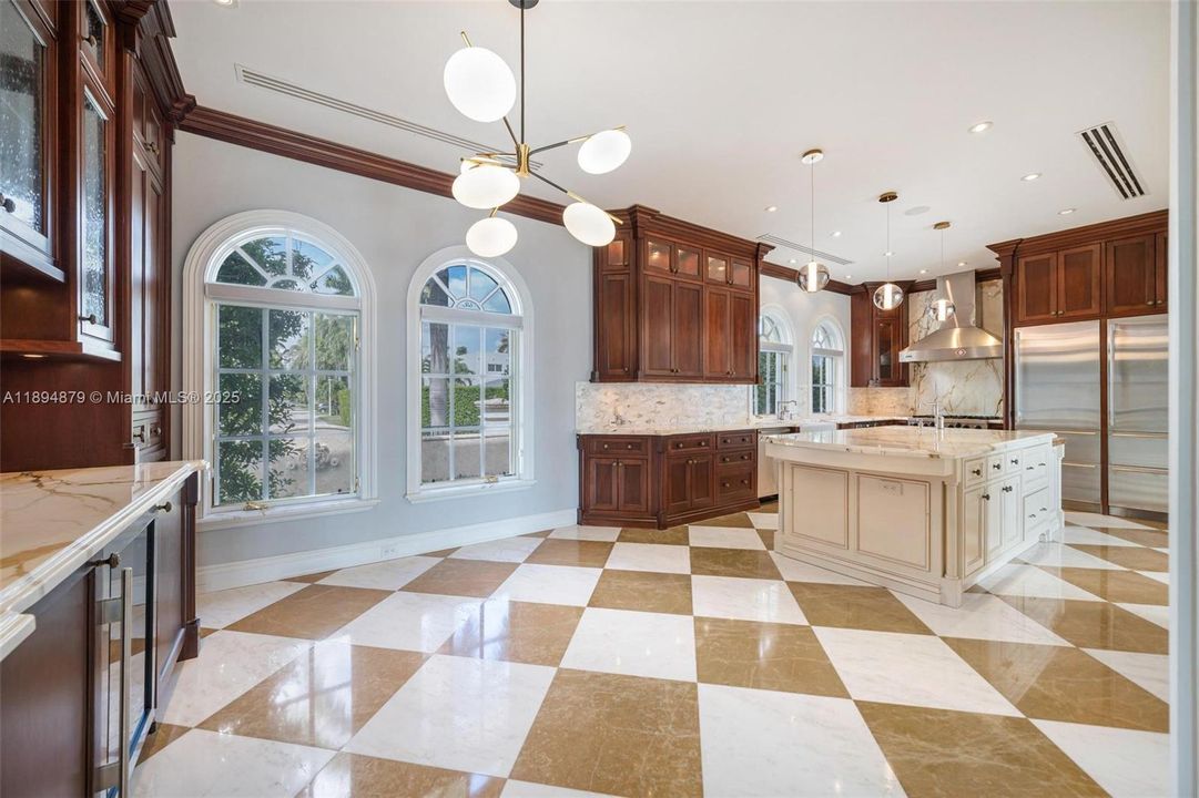 Gourmet kitchen with marble island and dual refrigerators/dishwashers