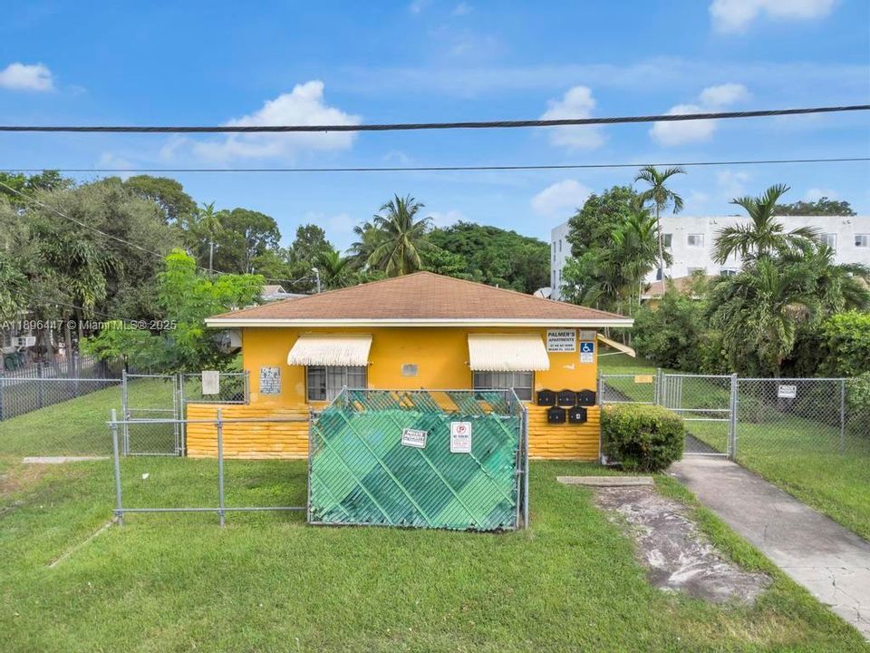 Alternate front angle highlighting the large 8,300 sq ft lot and ample green space around the property. Zoned T5-O for redevelopment potential up to 12 units.
