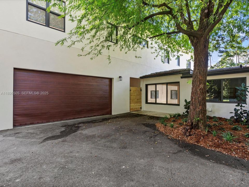 Circular driveway surrounded by mature trees, providing beauty, shade, and exceptional privacy — even when not entering through the garage.