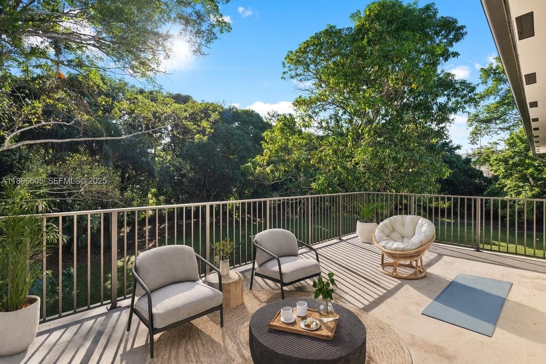 Expansive deck off the primary suite overlooking the lush, private backyard.