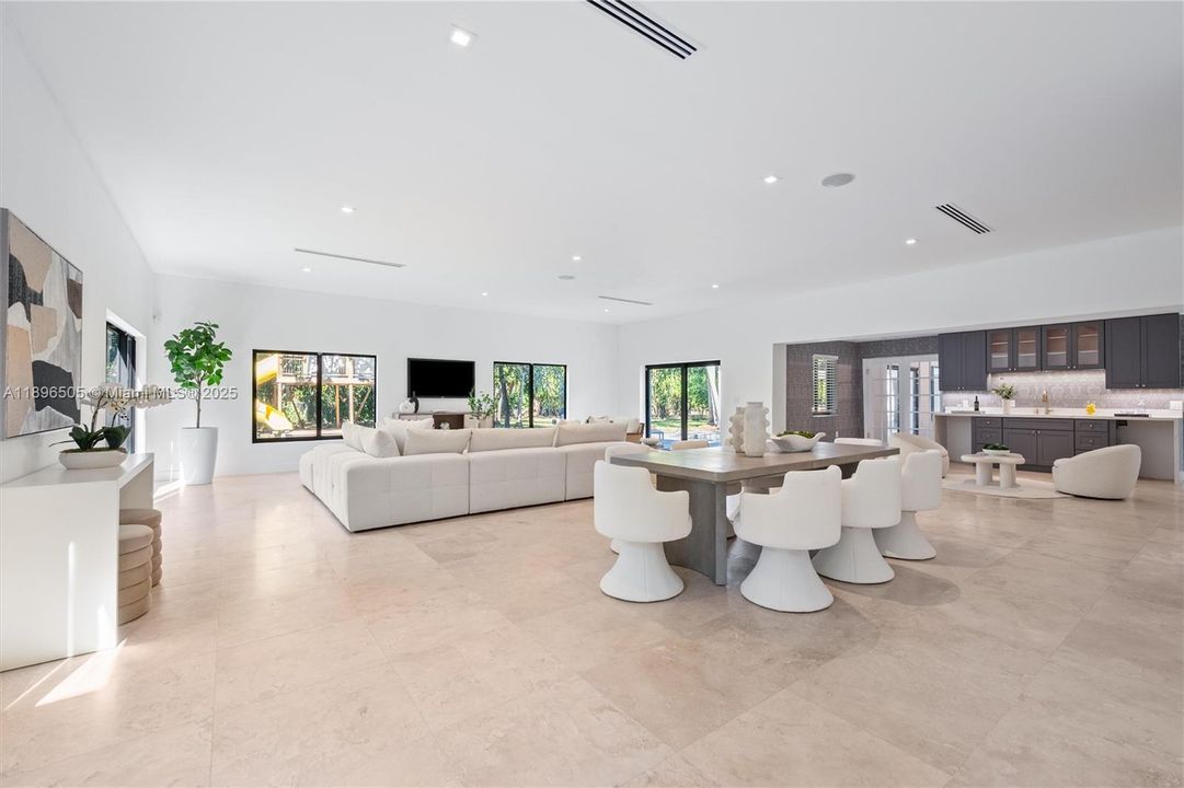 32’x27’8” great room surrounded by windows and a wet bar — a spacious, light-filled layout that allows multiple vignettes for living, dining, family, and seating areas.