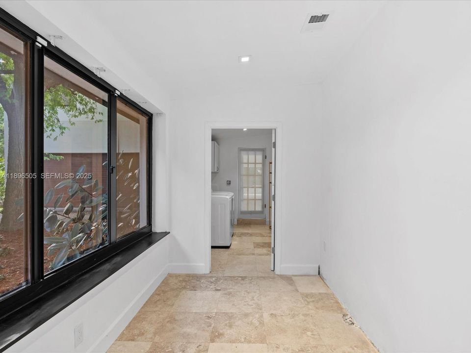 Versatile mudroom or office area and spacious laundry room with dual entry and exit for added functionality and convenience.