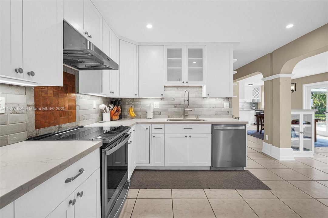 Contemporary kitchen design with sleek finishes, tile backsplash, and recessed lighting.