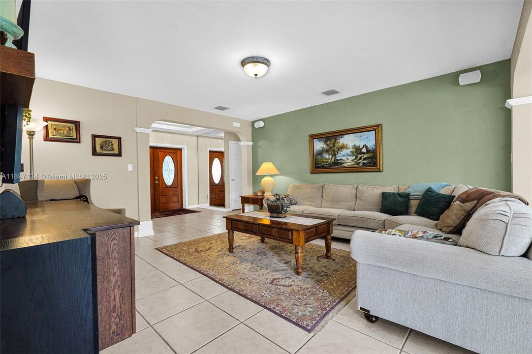 Open-concept living area with seating space overlooking backyard pool views.