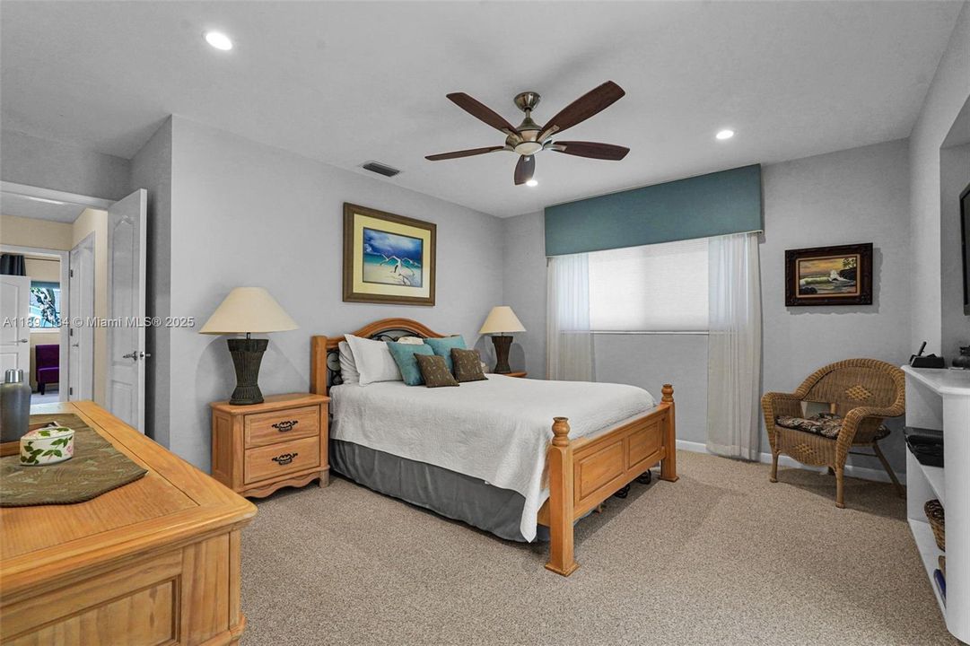 Primary suite with tray ceiling, tile floors, and private ensuite bath.