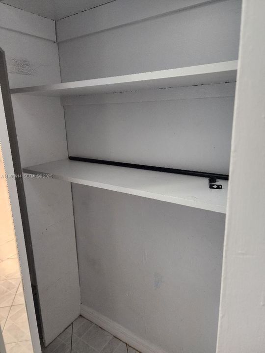 SHELVES IN THE HALL CLOSET INCLUDES AREA FOR HANING CLOTHES.