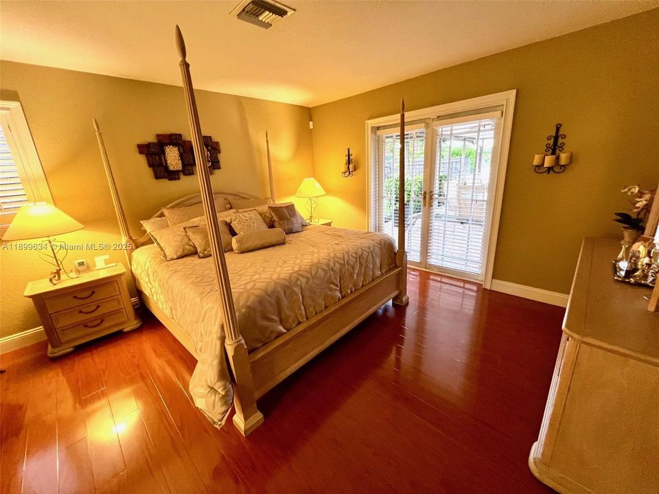 Primary bedroom has French doors with view of lake and patio