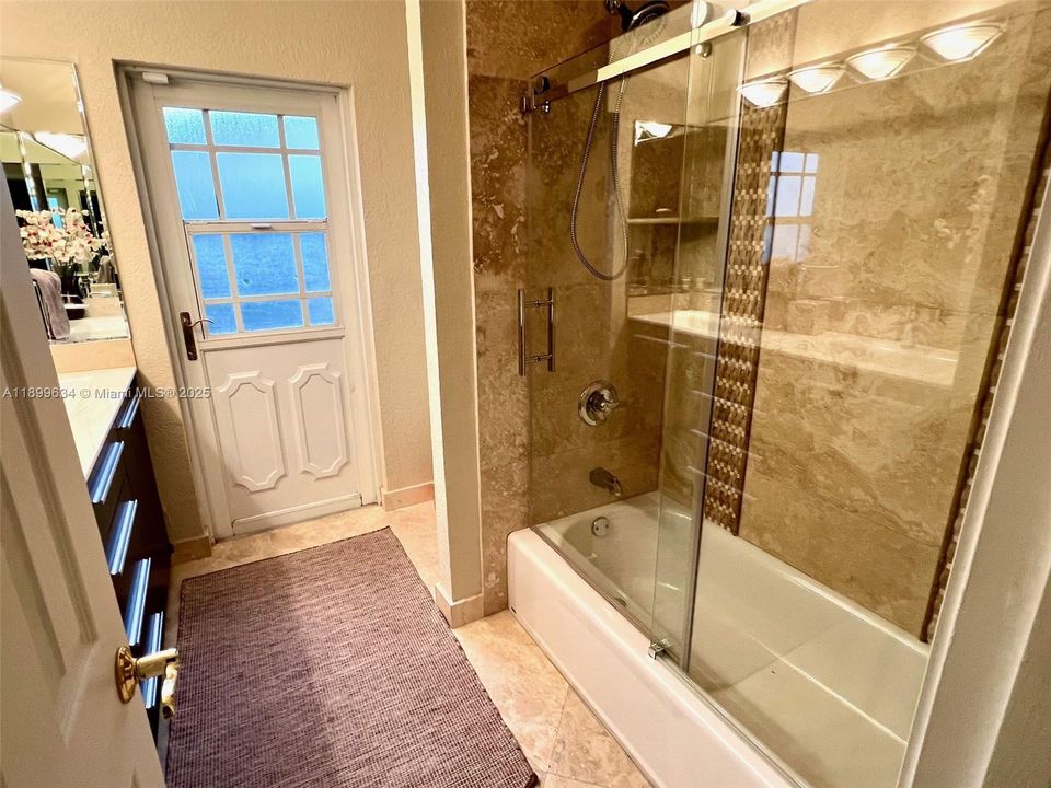 Main bathroom with granite countertop and double sinks and door to also use as cabana bathroom