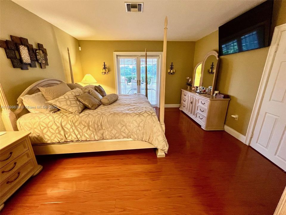 Primary bedroom has French doors with view of lake and patio