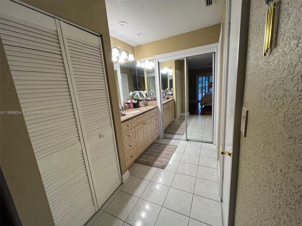 Ensuite with granite vanity countertop and lots of closet space