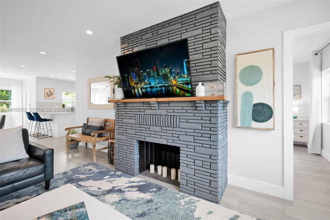 Cozy and contemporary living room featuring an elegant fireplace centerpiece — a rare find in South Florida homes.
