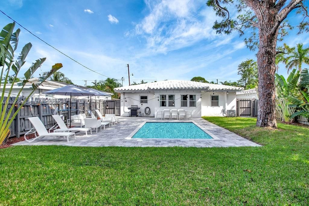 Expansive backyard with tropical landscaping and direct access to the pool area — ideal for outdoor living and gatherings.
