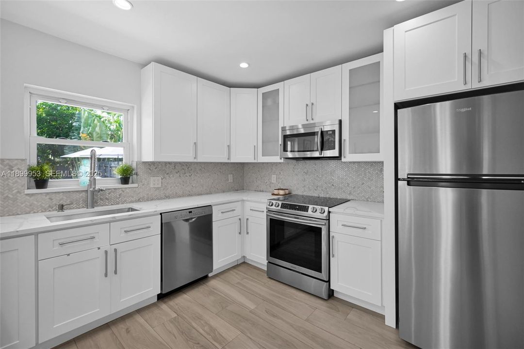 Gourmet kitchen designed with attention to detail — sleek lines, open shelving, and top-of-the-line finishes.