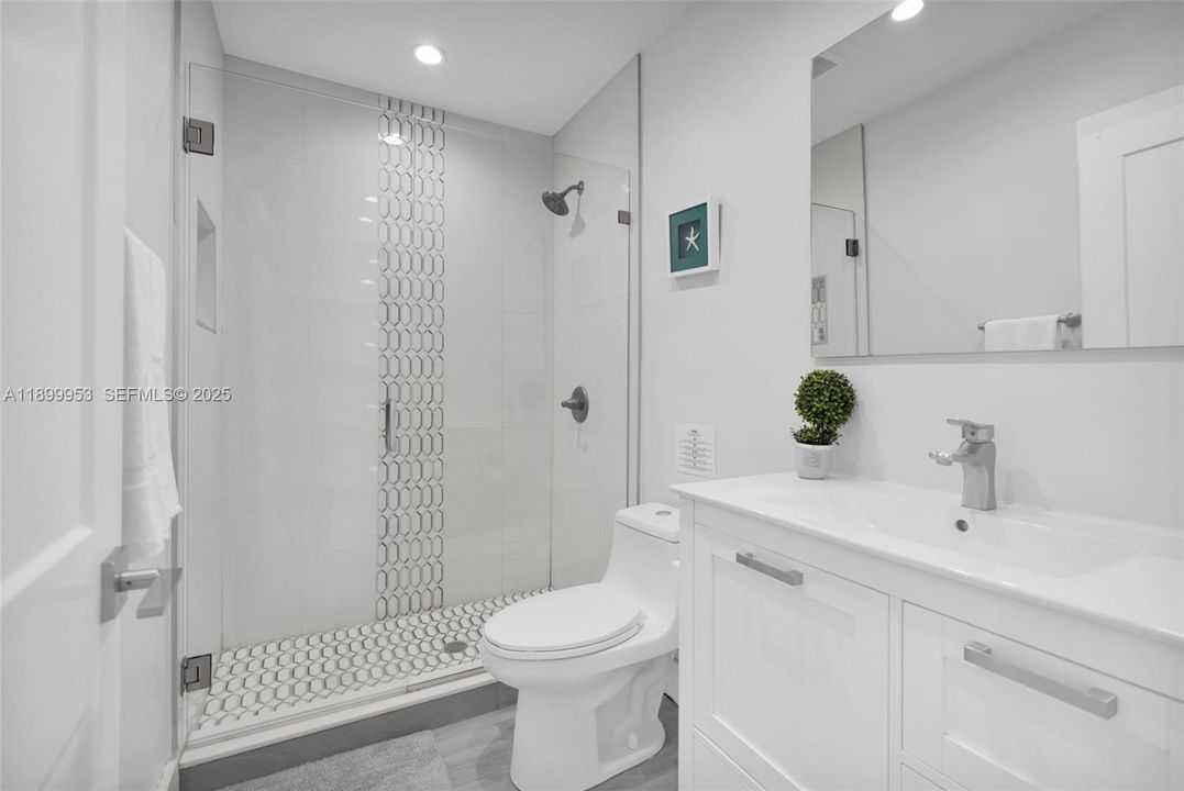 Elegant full bathroom with sleek finishes, and a spacious walk-in shower.