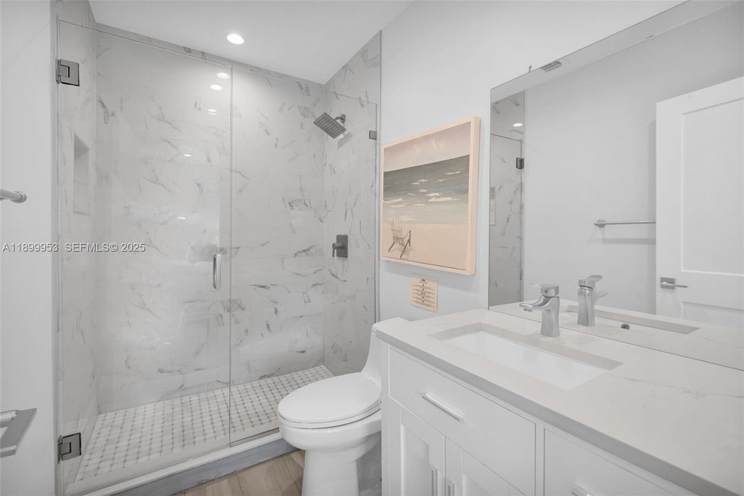 Stylish bathroom featuring a glass-enclosed shower and luxurious contemporary details.