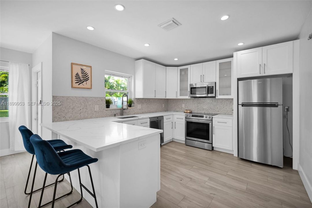Bright and modern kitchen with stainless steel appliances, quartz countertops, and custom cabinetry — designed for both function and style.