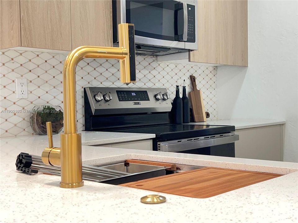 Undermount kitchen sink with a sapele wood cutting board, a stainless steel colander, a roll drying rack & a bottom rinse grid.