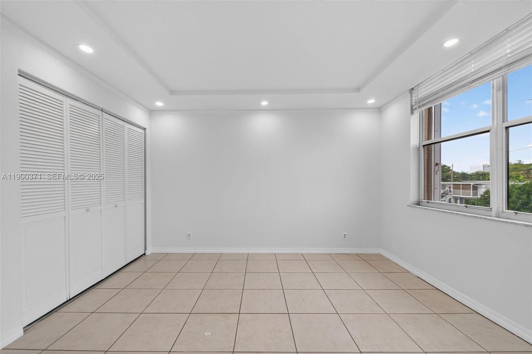 Guest Bedroom w/ wall of closets. Blinds, Trey Ceiling w/ high hat lights