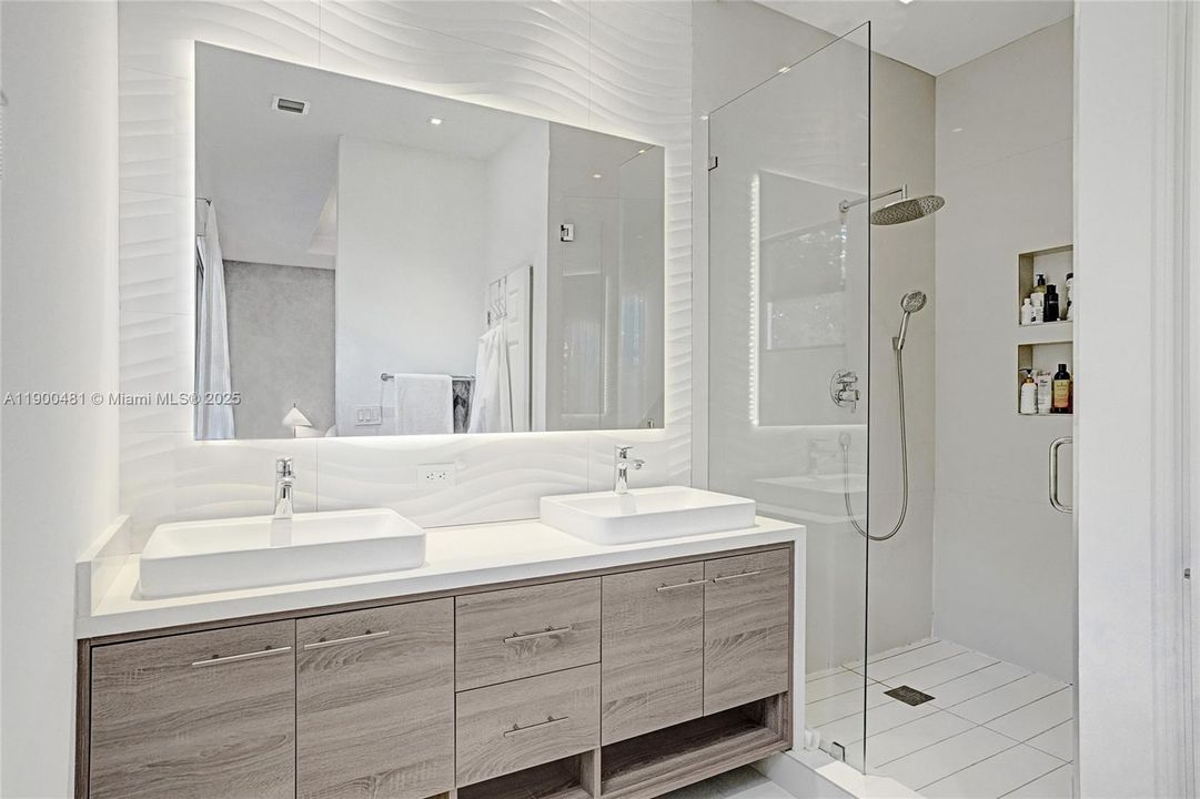 Dual vanities luxurious bathroom with glass-enclosed shower