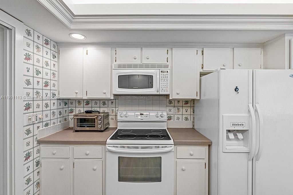 another angle of open and bright kitchen with snack counter.