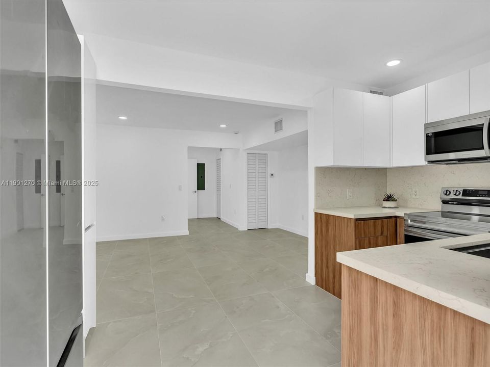 European-style kitchen with quartz counters, stainless steel appliances.