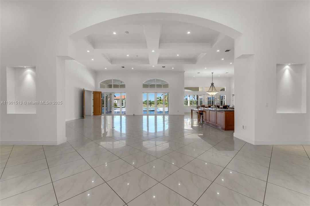 THE VIEW UPON ENTRY ...GREAT ROOM WITH 22' COFFERED CEILINGS, IMPACT THRU OUT. DOORS OPEN TO PROVIDE ACCESS TO THE RESORT LEVEL POOL/ COVERED AND OPEN-AIR PATIO. MEANDERING WELL LIT PAVER PATHWAYS PROVIDE EASY STROLLING TO SUMMER KITCHEN/ BAR AND BATH. ADDITIONAL PAVERS ARE IN PLACE FOR PARTIES ALFRESCO.