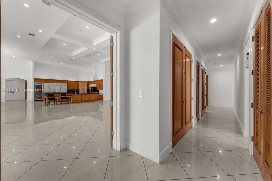 HALLWAY OFF OF GREAT ROOM TO ONE OF THE PRIMARY SUITES AND TOWARDS MEDIA THAT CAN ALSO BE REACHED FROM COVERED ENTRY